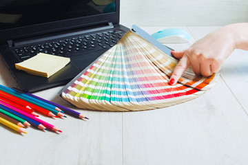 Woman designer chooses color from color palettes