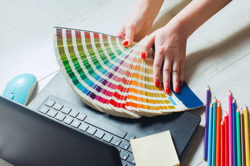 Woman designer chooses color from color palettes
