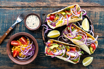 Mexican tacos with chicken meat, vegetables and fresh greens