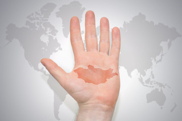 hand with map of mongolia on the gray world map background.