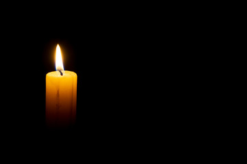 burning wax candle on a black background