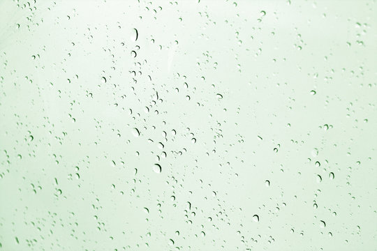 Blured water drops on window in green tone.