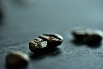 Focus sur un seul grain de café sur un fond de nombreux grains de café sur un tableau noir de pierre
