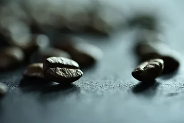  Focus sur un seul grain de café sur un fond de nombreux grains de café sur un tableau noir de pierre © Joanna