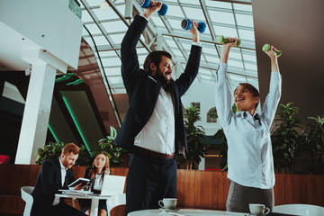 Happy Office Workers Working with Dumbbells
