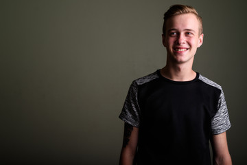 Fototapeta premium Young handsome man with blond hair against colored background