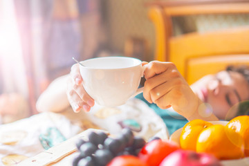 human hand pick some food from the tray in the morning lying in bed f