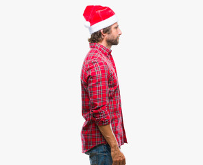 Handsome hispanic man model wearing santa claus christmas over isolated background looking to side, relax profile pose with natural face with confident smile.