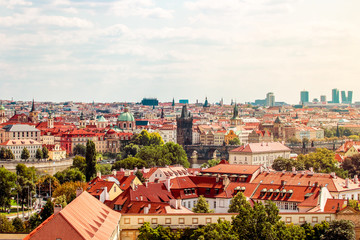 Obraz premium Prague, Bohemia, Czech Republic. Scenic view of bridges on the Vltava river and of the historical center of Prague : Old town bridge tower and landmarks of old town with red rooftops and houses.