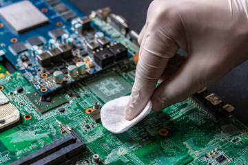 master repair the computer parts, cleaning the board using the cotton wool tampon f