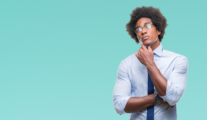 Fototapeta na wymiar Afro american business man wearing glasses over isolated background with hand on chin thinking about question, pensive expression. Smiling with thoughtful face. Doubt concept.
