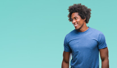 Afro american man over isolated background looking away to side with smile on face, natural expression. Laughing confident.