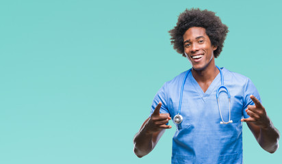 Afro american surgeon doctor man over isolated background shouting with crazy expression doing rock...
