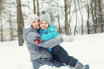 Obraz premium Mom and little son playing in the snow in winter