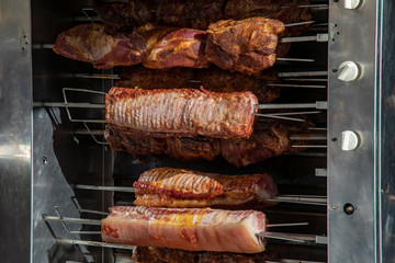 Roll roast on a skewer and ham on a spit in the grill
