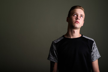 Obraz premium Young handsome man with blond hair against colored background