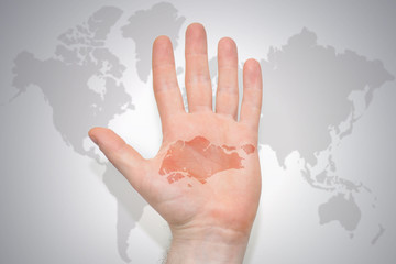hand with map of singapore on the gray world map background.