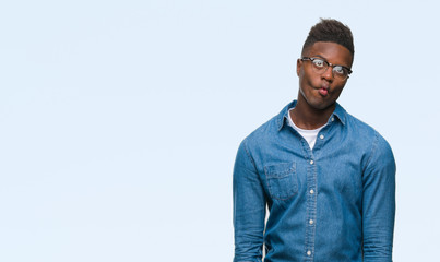 Fototapeta premium Young african american man over isolated background making fish face with lips, crazy and comical gesture. Funny expression.