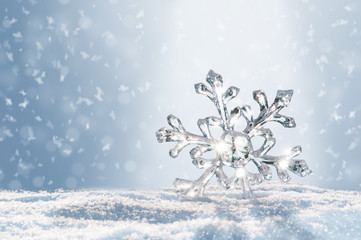 Leuchtender großer Eiskristall im Schnee, Bokeh des Winters glitzert im winterlichen Hintergrund