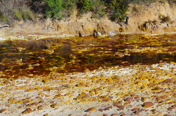 River polluted by gold mine in dry valley with trees, Río Tinto in Huelva, Andalucía, Spain