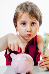 Fototapeta na wymiar Money should be in the bank concept. Cute little business child girl with piggy coin bank and US Dollar bills.