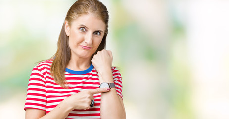 Middle age mature woman wearing casual t-shirt over isolated background In hurry pointing to watch time, impatience, upset and angry for deadline delay