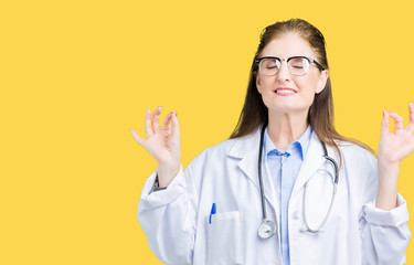 Middle age mature doctor woman wearing medical coat over isolated background relax and smiling with eyes closed doing meditation gesture with fingers. Yoga concept.