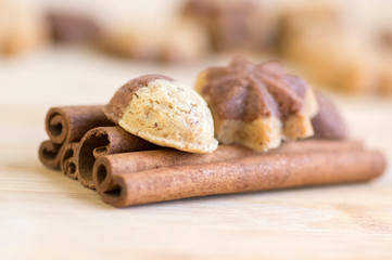 Cinnamon sandbakelse christmas cookies, two colors, cocoa dark brown and vanilla light golden brown, cinnamon raw bark spice