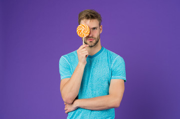 Man with bristle likes lollipop. Cheat meal concept. Sugar harmful for health. Guy hold lollipop...
