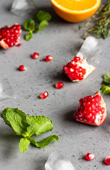 Food background with ingredients for making pomegranate lemonade on a grey slate, stone or concrete table. Copy space.