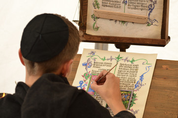 Young male medieval scribe make manuscript - calligraphy