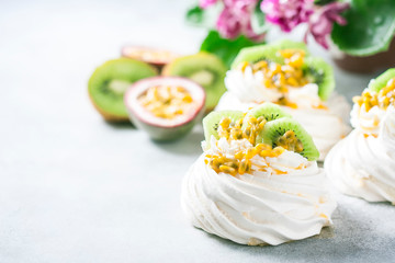 Fototapeta na wymiar Homemade cake Pavlova with whipped cream, fresh kiwi and passion fruit.