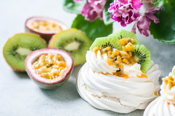Obraz na płótnie Canvas Homemade cake Pavlova with whipped cream, fresh kiwi and passion fruit.