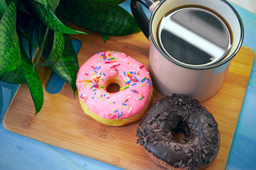 Delicious donuts with a cup of coffee are on the table