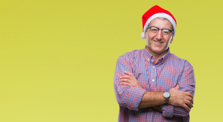 Handsome senior man wearing christmas hat over isolated background happy face smiling with crossed arms looking at the camera. Positive person.