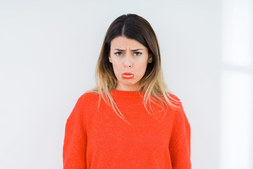 Obraz premium Young woman wearing casual red sweater over isolated background depressed and worry for distress, crying angry and afraid. Sad expression.