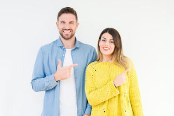 Young beautiful couple togheter over isolated background cheerful with a smile of face pointing with hand and finger up to the side with happy and natural expression on face