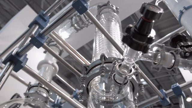 Laboratory equipment for vacuum distillation, glass flasks, tubes, coils and other equipment for the chemical industry. Shot in motion

