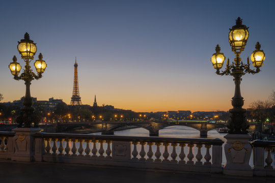 Paris, France - 11 18 2018: panoramic view of Paris and the Eiffel Tower from the Alexander III bridge with floor lamp at sunset