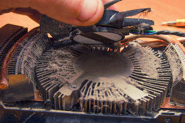 Dust on the computer pc processor cooler with mainboard and computer case fragment. Selective...