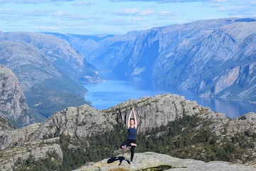 Fototapeta premium hiker girl doing yoga poses on the mountains