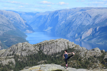 hiker girl doing yoga poses on the mountains