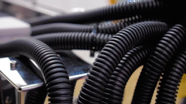 A large bundle of black corrugated tubes to protect electrical and other cables are connected to the equipment. Shot in motion