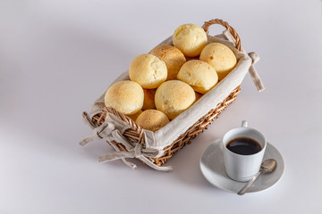 Brazilian homemade cheese bread, AKA 'pao de queijo' in a rustic basket and a cup of coffee