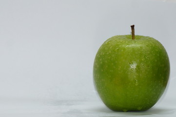 green apple with drops of water isolated on white