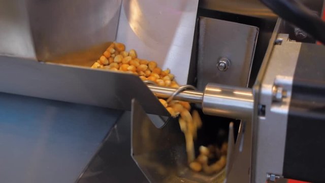 A popcorn machine produces large quantities of popcorn from corn grain without human intervention. Shot in motion
