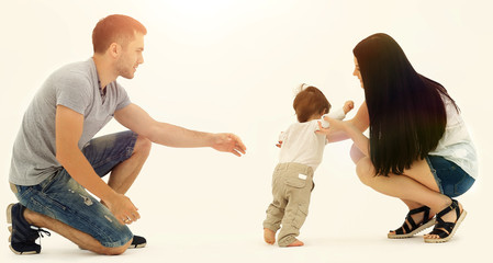 Portrait of a happy family that teaches a child to walk