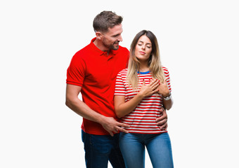 Fototapeta premium Young couple in love over isolated background smiling with hands on chest with closed eyes and grateful gesture on face. Health concept.