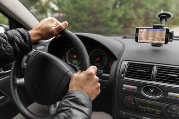 a driver in a car performs tasks necessary to steer the vehicle