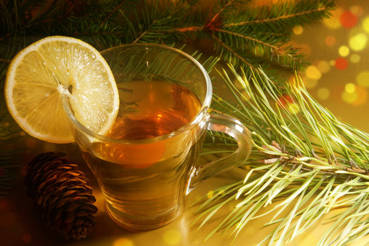 hot tea with a slice of lemon on new year's eve spruce and pine branches